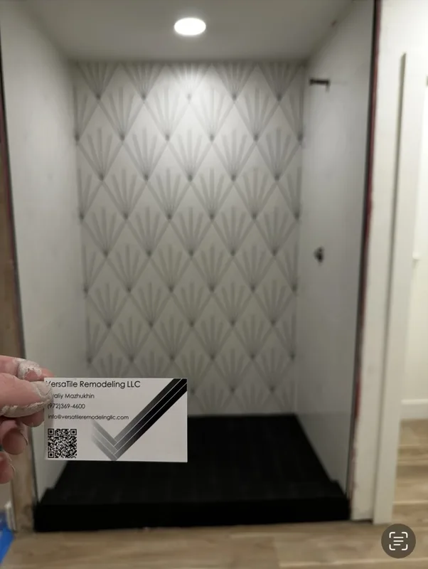 A patterned feature wall with a dark shower floor.