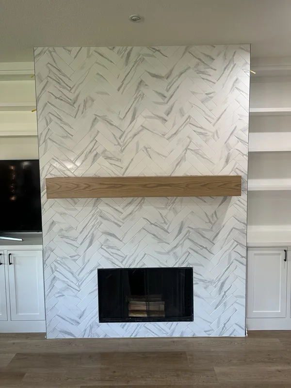 A full-height tile surround with a wood mantel.