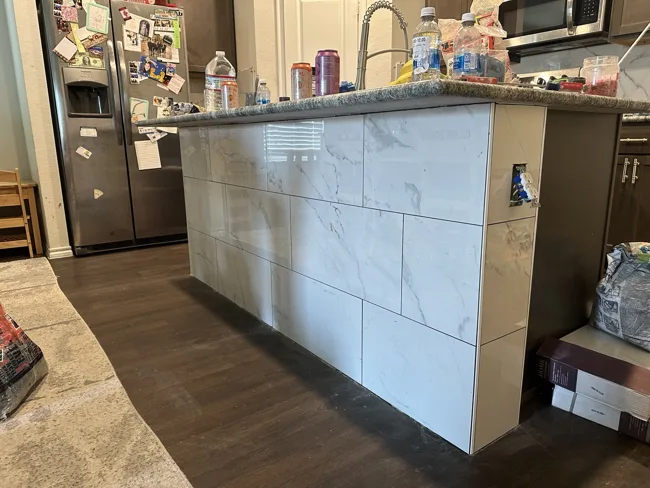 Large-format tile on the face of a kitchen bar.