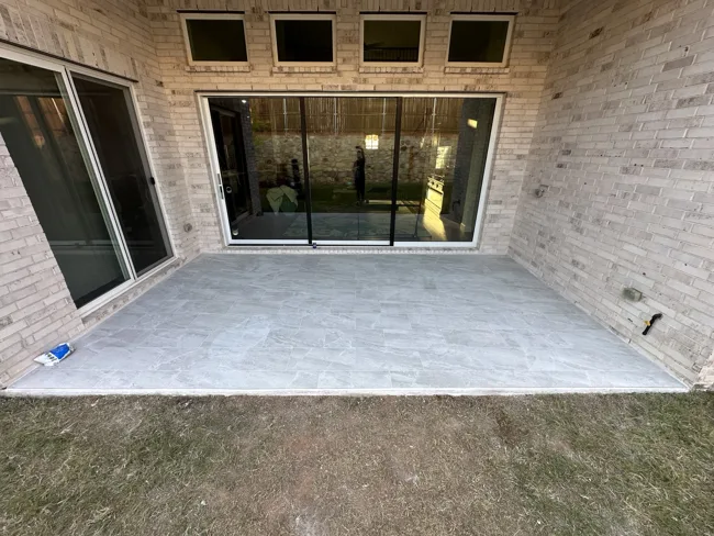 Light-colored tile across a covered outdoor living space.