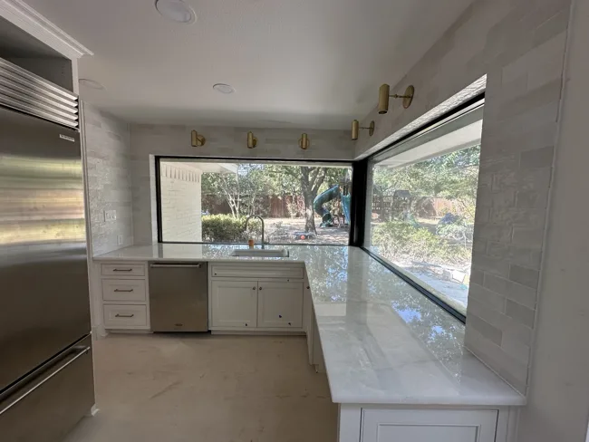 Light tile around a bright kitchen window.