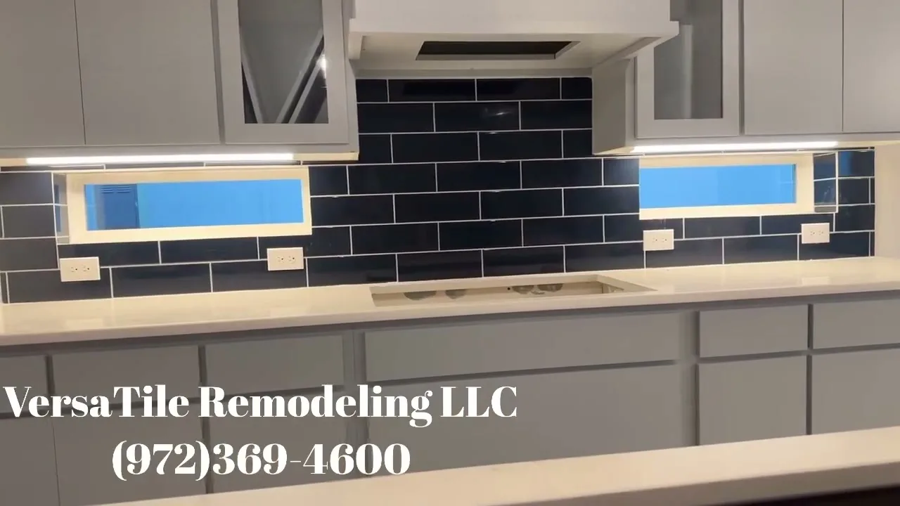 Glossy navy subway tile backsplash with under-cabinet lighting and gray cabinetry.